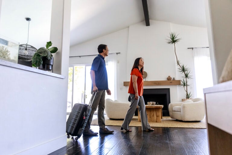 Couple with their luggage walking into a beautiful vacation rental.